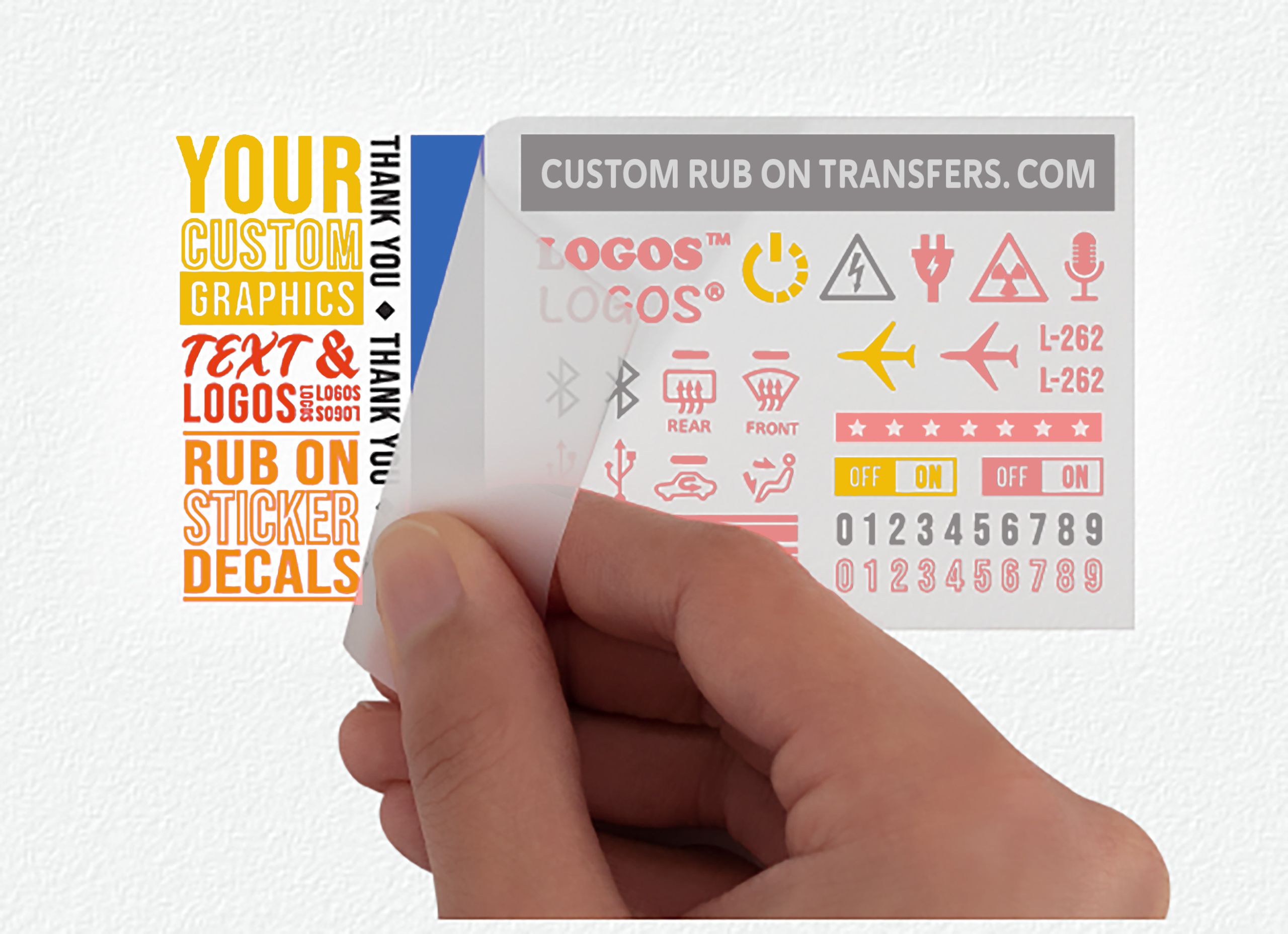 A hand peeling away a transparent transfer sheet from a white background. The Multi-Color Ensemble™ Transfer sheet ready to transfer in 1 application contains various red, yellow, and black custom graphics, texts, and logos including an airplane, audio waves, and numbers. The text "CUSTOM RUB ON TRANSFERS.COM" graces the top of this ready-to-transfer sheet.