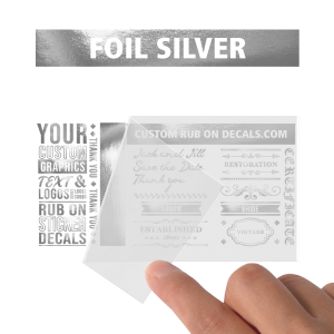 A person holding up a Foil Silver Custom Dry Rub transfer sticker.