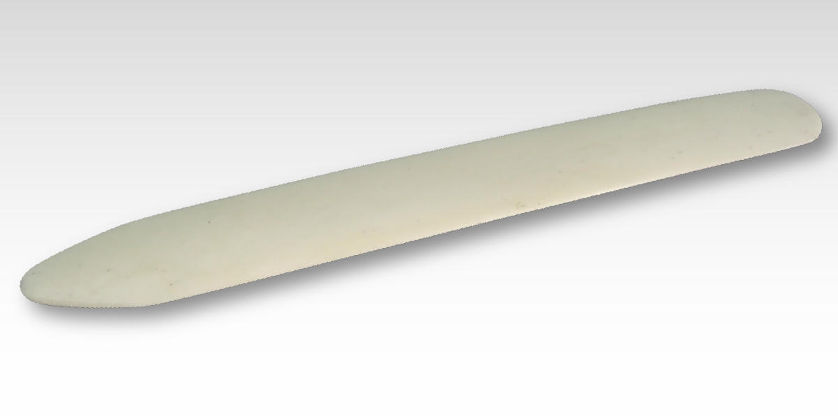 A custom rub on transfer of a white stone knife on a grey background.
