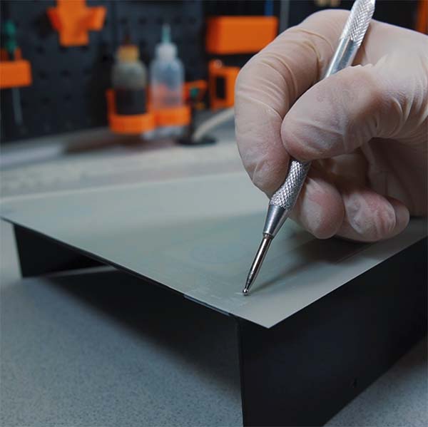 A person using a pen to make a hole in a piece of paper. A person using a pen to make a hole in a piece of paper.