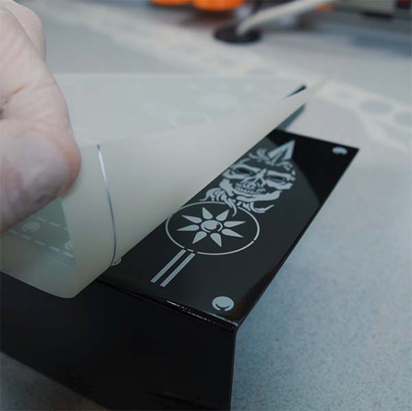 A person is using a dry transfer to put a piece of paper into a box.